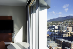 Guest room interior with sheer curtains and city view at Crowne Plaza Hobart.