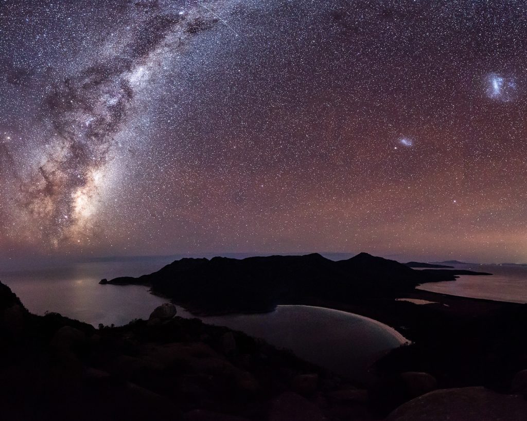 Milky Way over Tasmanian coastal bay with mountain silhouettes