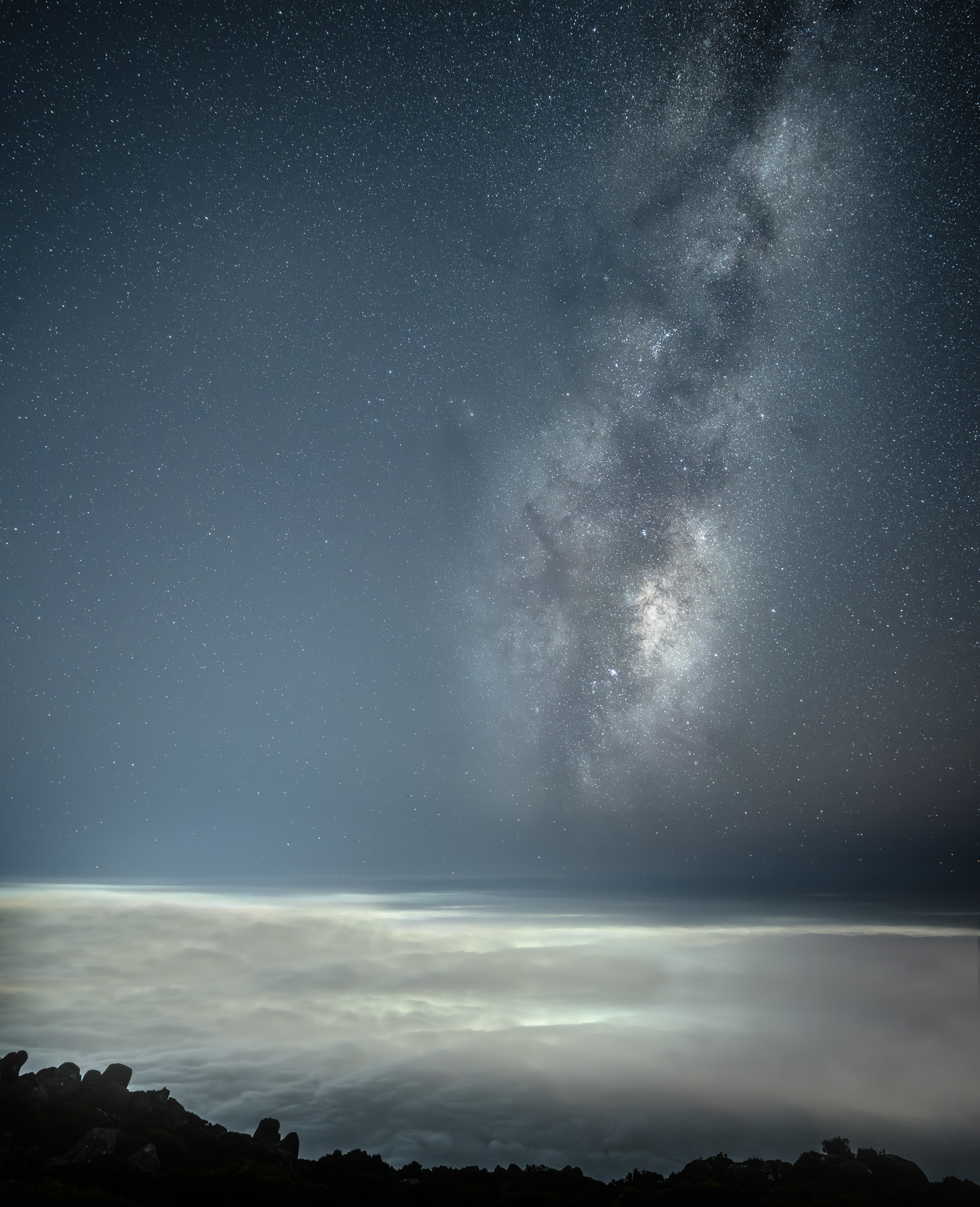 Milky way rise above a sea of clouds over the city of Hobart